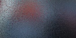 Textured glass surface with a subtle gradient from deep blue to warm red.