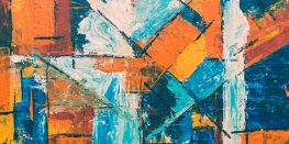 Abstract geometric painting with vibrant orange, blue, and white shapes.